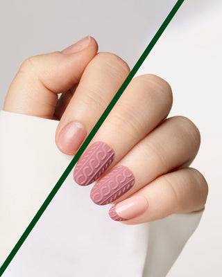 A close-up of a hand with manicured nails, featuring two medium pink nails with a raised cable-knit pattern and one pale pink nail with a small white accent, set against a clean white background with a diagonal dark green line.